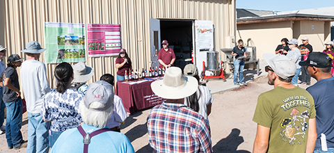 An Ag Extension agent teaching a course to a group of people outside.