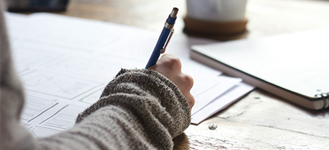 person writing on notebook