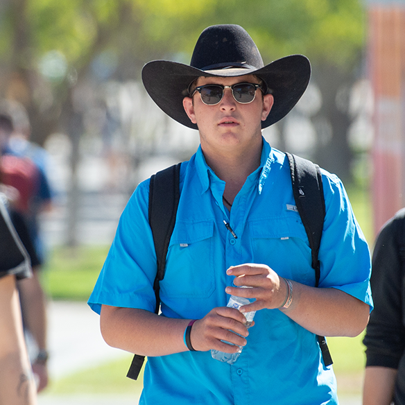 Student wearing cowboy hat, holding water bottle