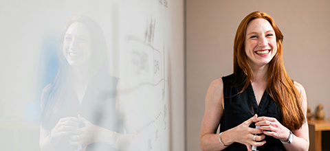 a teacher standing in front of a white board