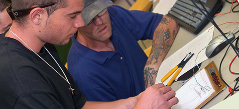 student and professor engaging in electronics