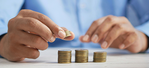 A man counting coins on a counter. 
