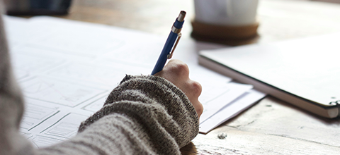 A hand writing with a pencil. 