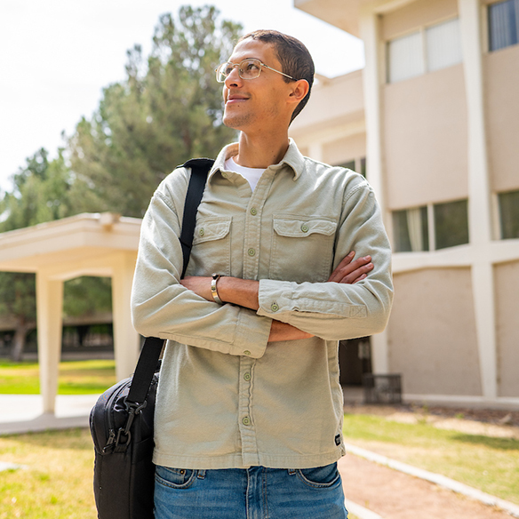 A student standing outside on NMSU's main campus.