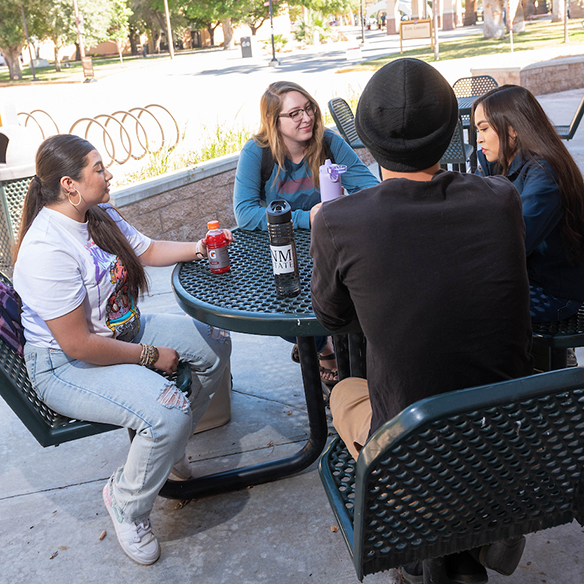 a group of students gathered at an outdoor table