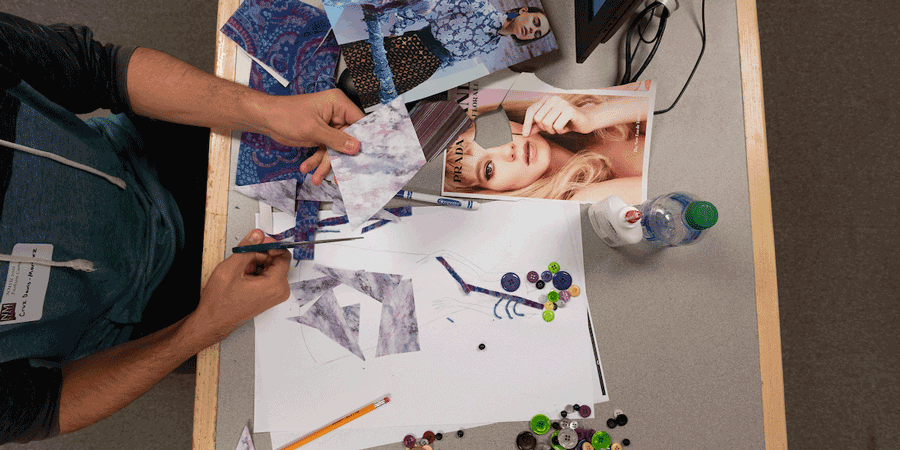 Student with fashion design items on a desk.