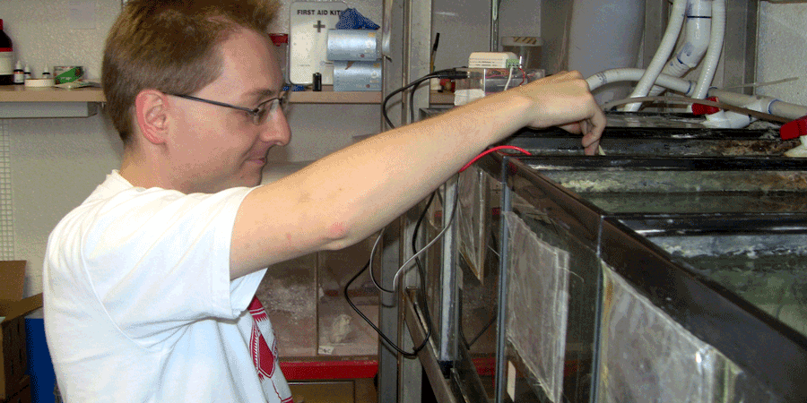 Student testing water in a tank.
