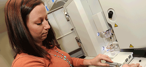 Student testing samples in a lab.