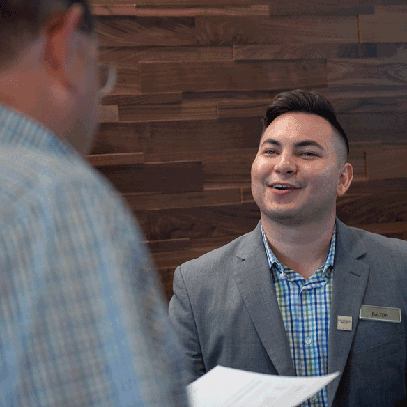 Student working in hotel front desk and checking in a client.