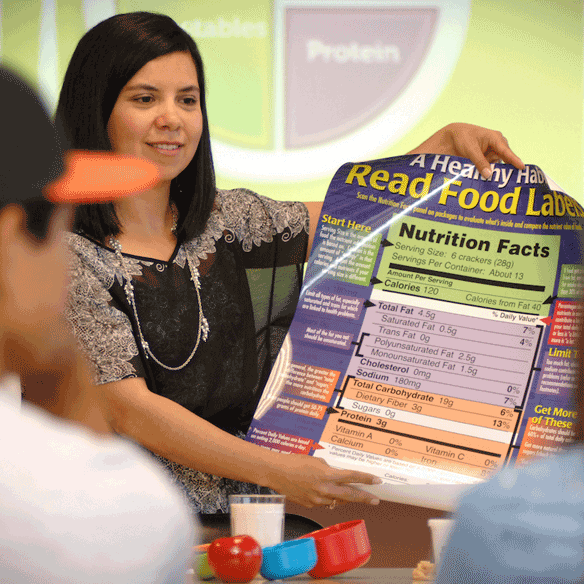 Student showing others a nutrition poster.