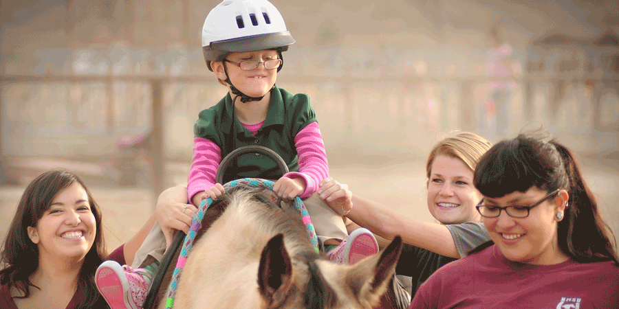 Student with fashion design items on a desk.