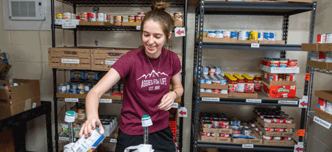 Student in a food pantry sorting items.