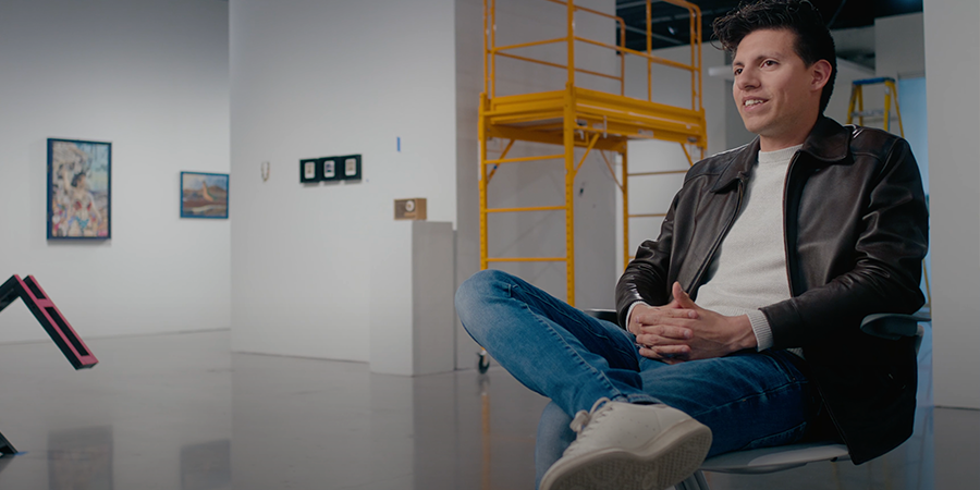 Student sitting cross legged in a studio setting.