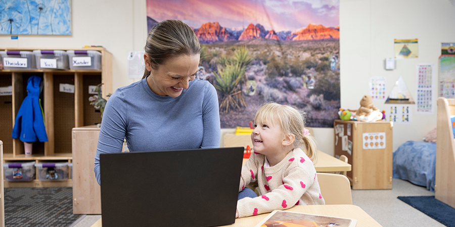 Young girl with teacher looking at computer