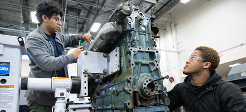 students working on a mechanical engine