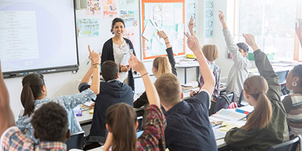 Elementary School Children posing for photograph in front of chalkboard