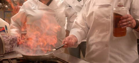 A husband and wife sit on a couch with their son and daughter having a conversation.
