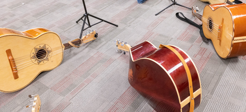 A collection of guitars resting on the groud
